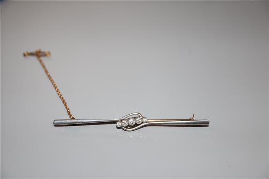 An early 20th century 15ct and graduated five stone diamond set bar brooch, 76mm, gross weight 5.7 grams.